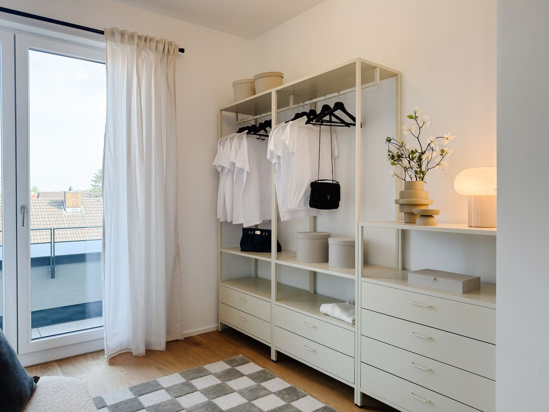 Stilvolles Schlafzimmer mit angrenzender Ankleide einer exklusiven Penthouse-Musterwohnung in Eppelheim nach hochwertigem Home Staging durch Anja Krohnen Home Staging.