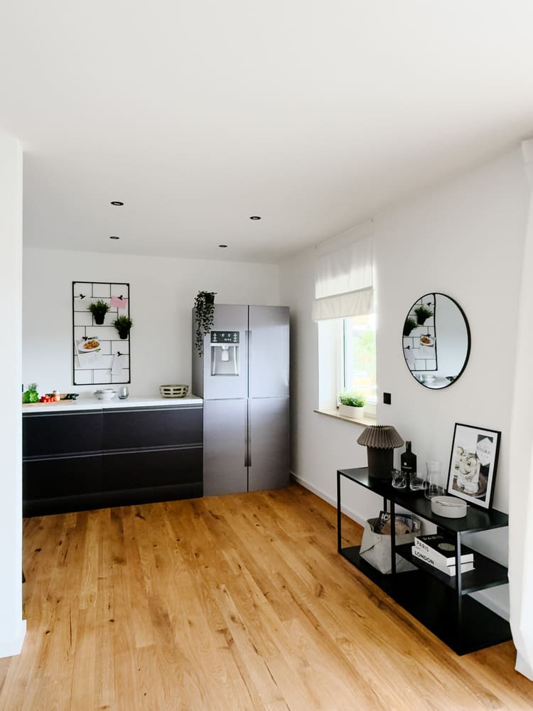 Einblick in schwarze Cubiqz Küche mit amerikanischem Kühlschrank in einer renovierten Fix-&-Flip-Wohnung in Kleinostheim nach professionellem Home Staging.