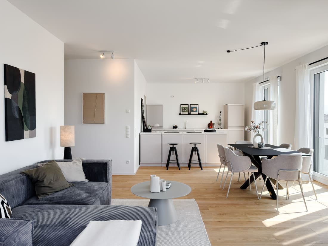 Offener Wohn-, Ess- und Küchenbereich einer exklusiven Penthouse-Musterwohnung in Eppelheim nach professionellem Home Staging durch Anja Krohnen Home Staging.