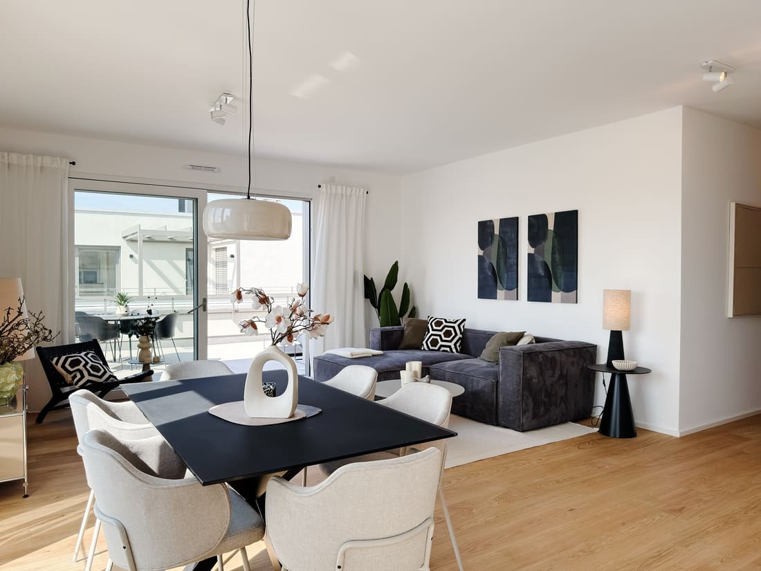 Elegant eingerichtete Wohn-Ess-Küche einer Penthouse-Musterwohnung in Eppelheim nach professionellem Home Staging für einen Bauträger durch Anja Krohnen Home Staging.